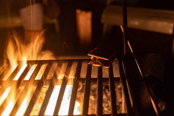 A s'more roasting on the grill over the firepit at a getaway house proptery