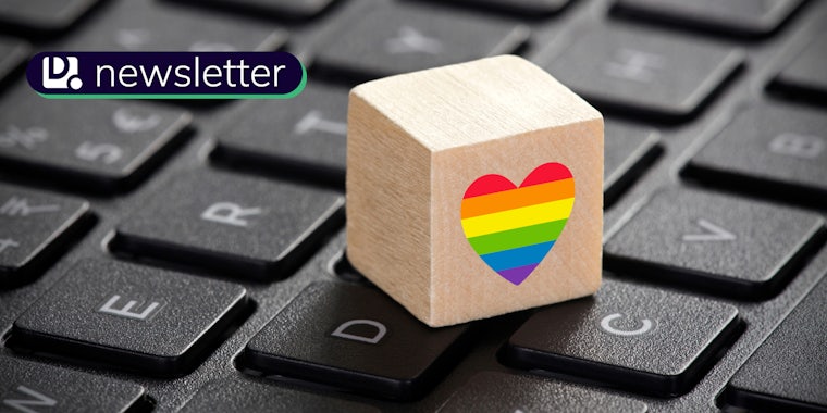 A wooden cube with the LGBTQ rainbow heart symbol sitting on a keyboard. The Daily Dot newsletter logo is in the top left corner.