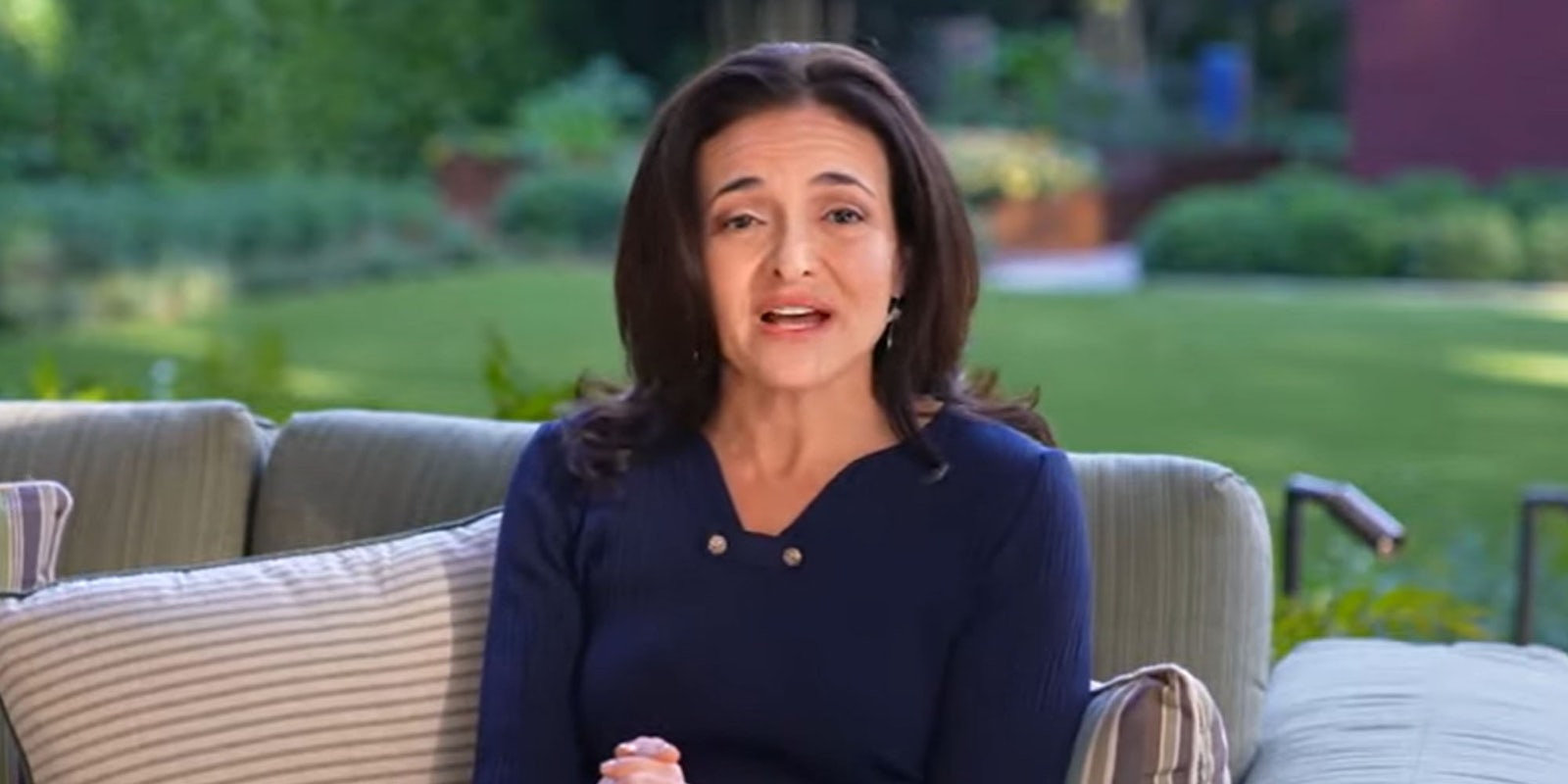 Sheryl Sandberg speaking in chair outside