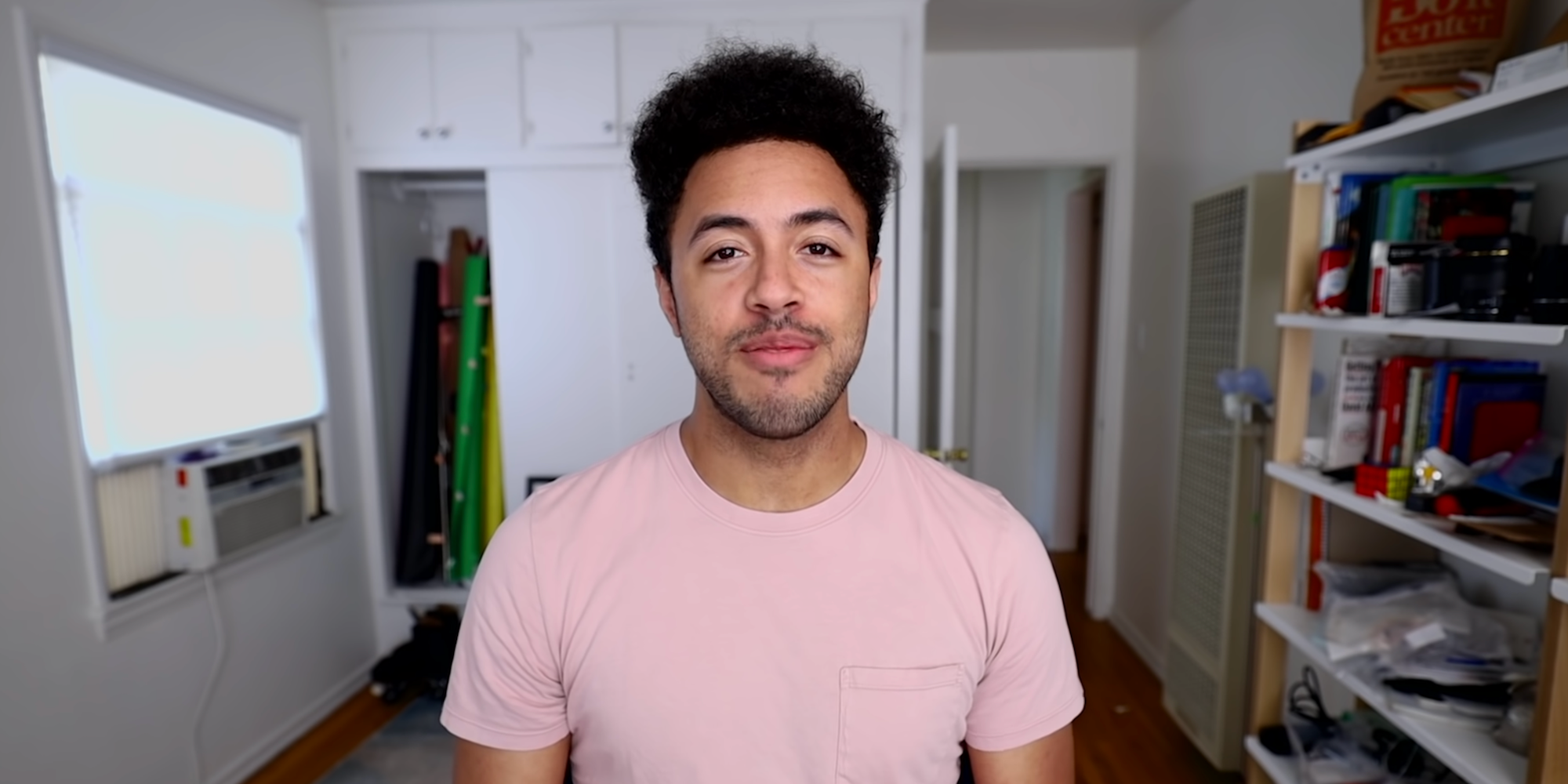 Jarvis Johnson looking at the camera, wearing a pink T shirt.