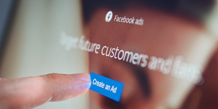 Finger touching on Create an Ad button on Facebook website.