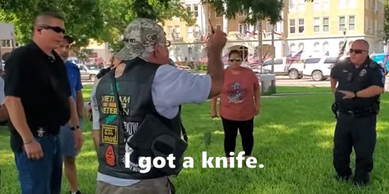 Vietnam vet grandpa holding out knife in group with police outside caption 'I got a knife.'