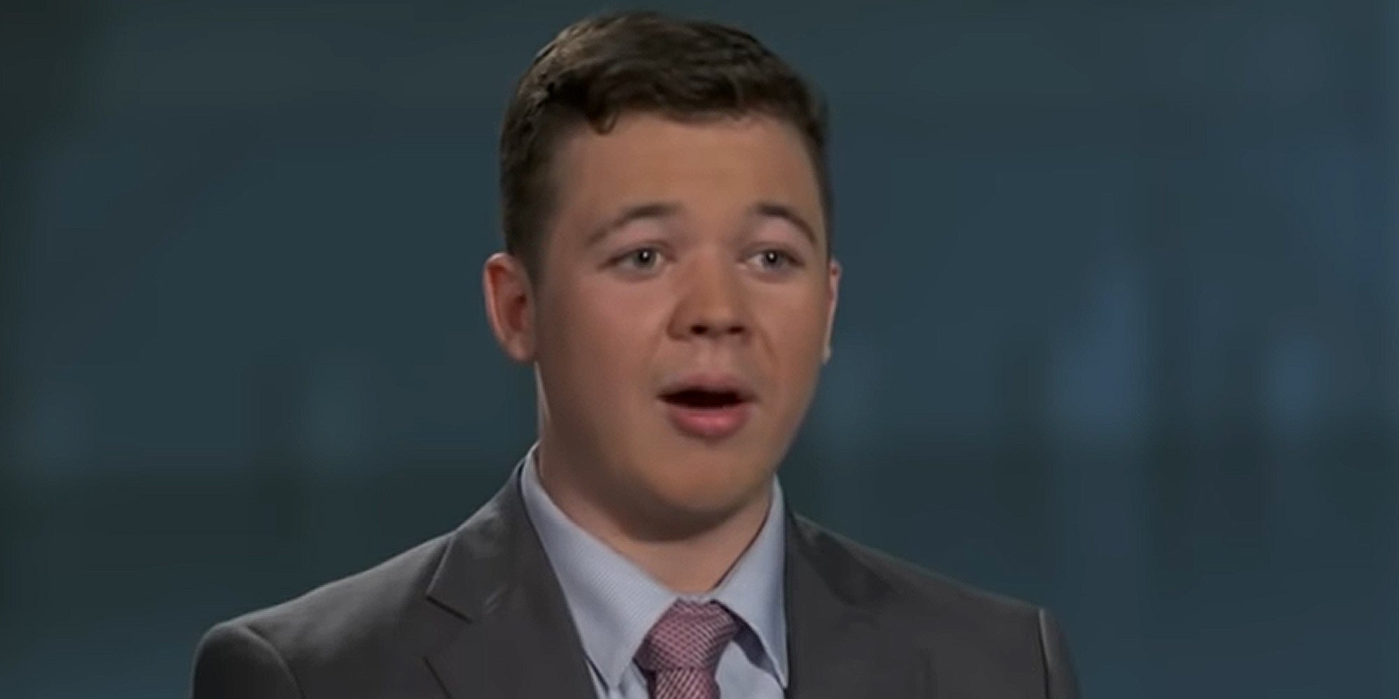 Kyle Rittenhouse talking on jean blue/gray background