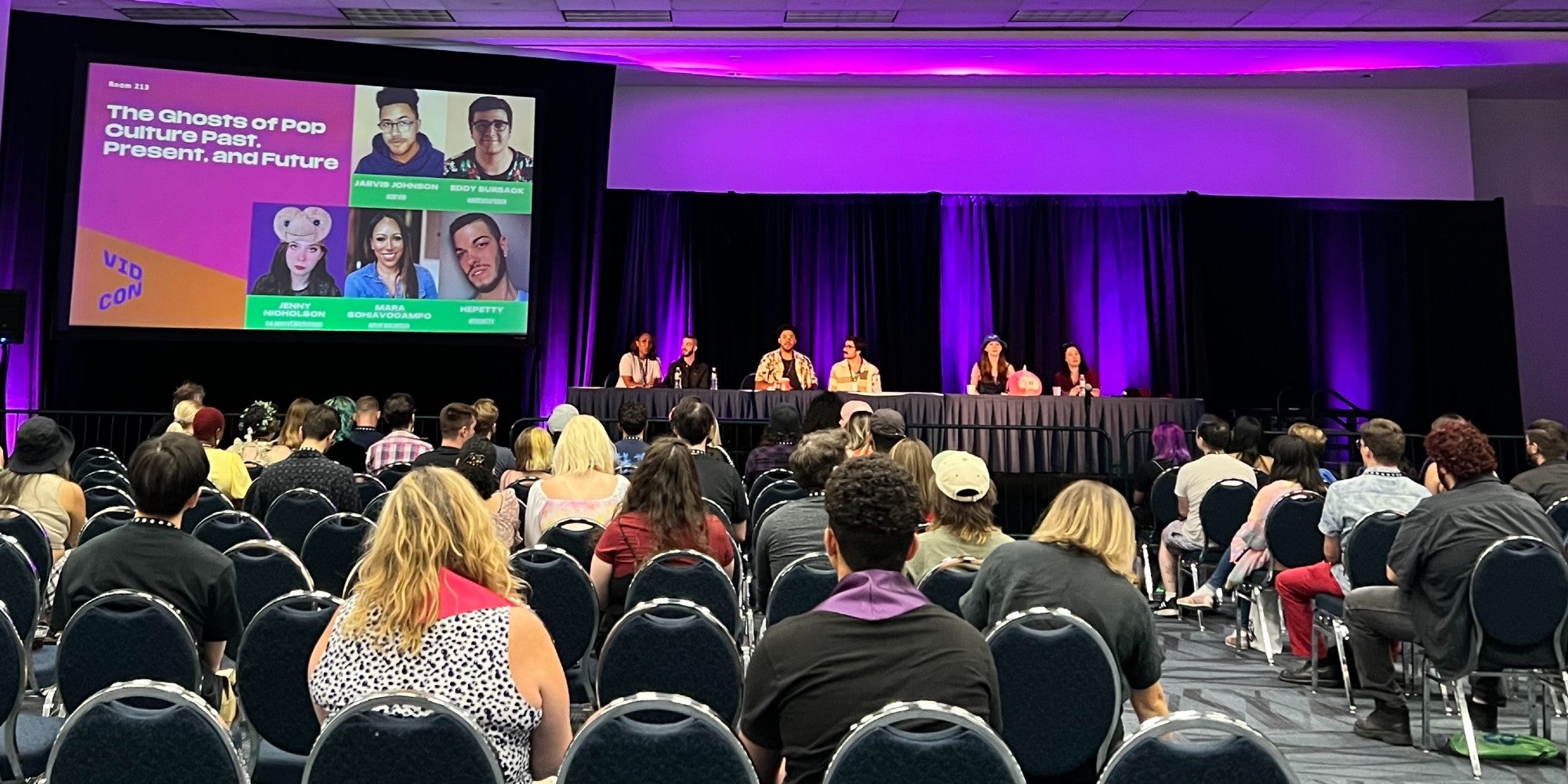 A panel of 6 people with an audience