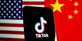 TikTok app on phone over US and Chinese flags