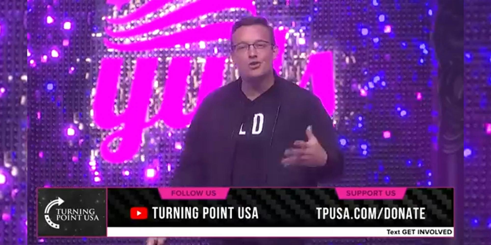 man on stage with "Turning Point USA" overlay
