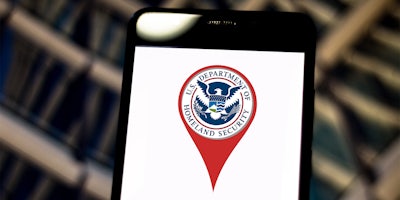 DHS logo inside red location pin on phone screen