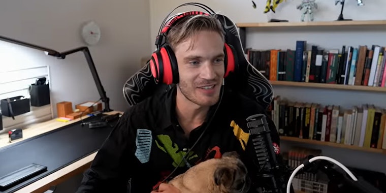 PewDiePie sitting in chair holding Maya (his dog)