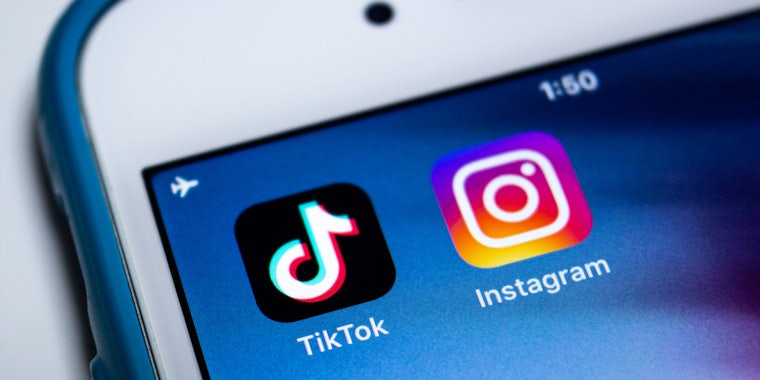 iPhone open with apps TikTok and Instagram on screen on blue background