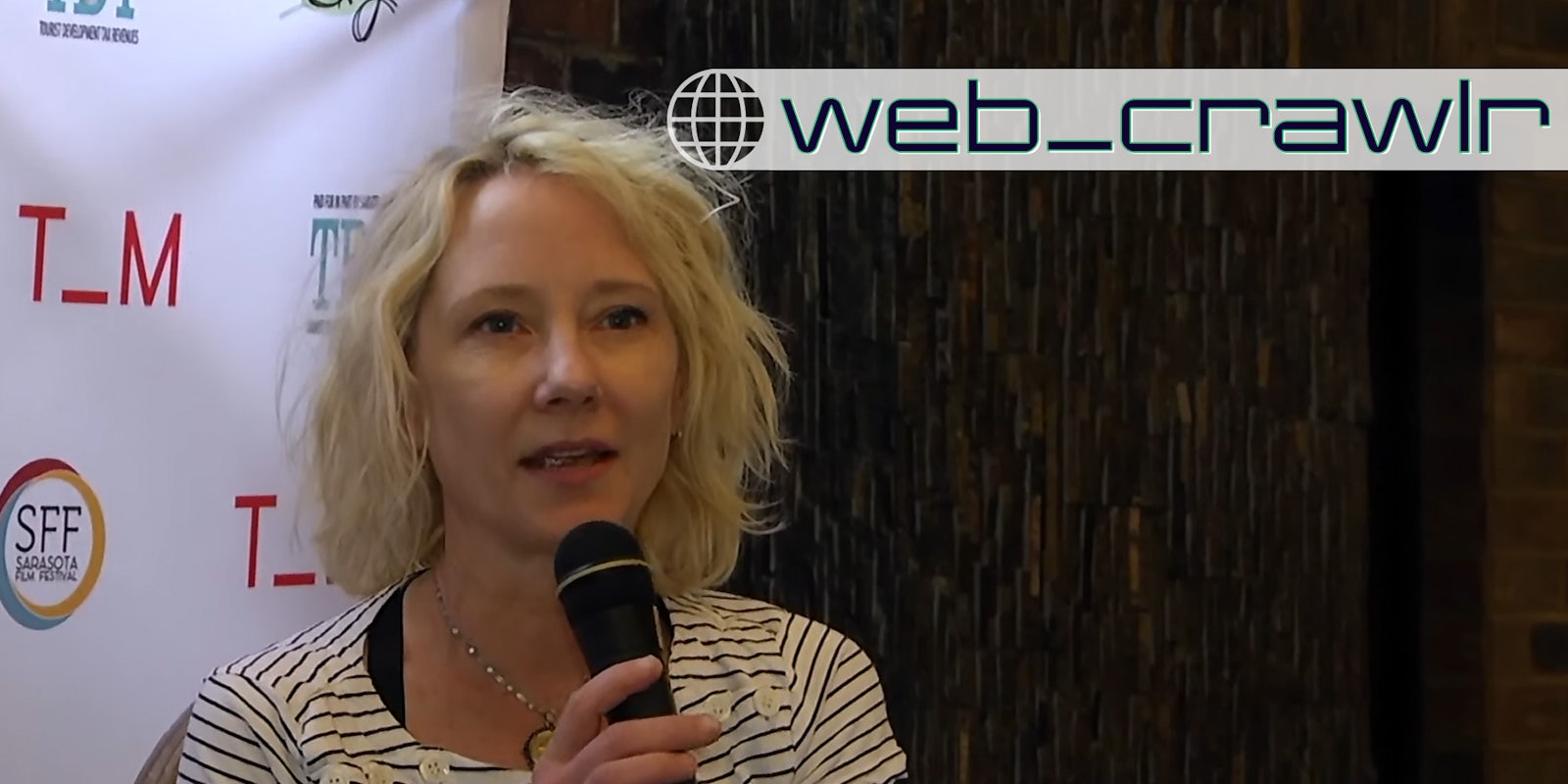 Anne Heche speaking into a microphone. The Daily Dot newsletter web_crawlr logo is in the top right corner.