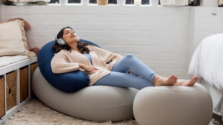 Woman wearing headphones relaxing on a Moon Pod