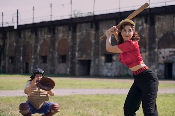 carson (left) catching and greta (right) at bat in a league of their own tv show