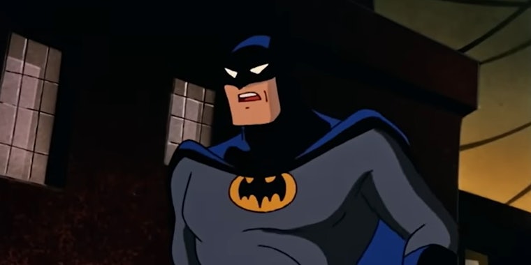 Batman in alley buildings behind him with yellow sky from batman: the animated series