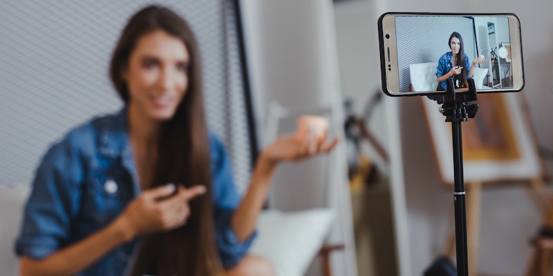 Woman using a smartphone camera on a tripod