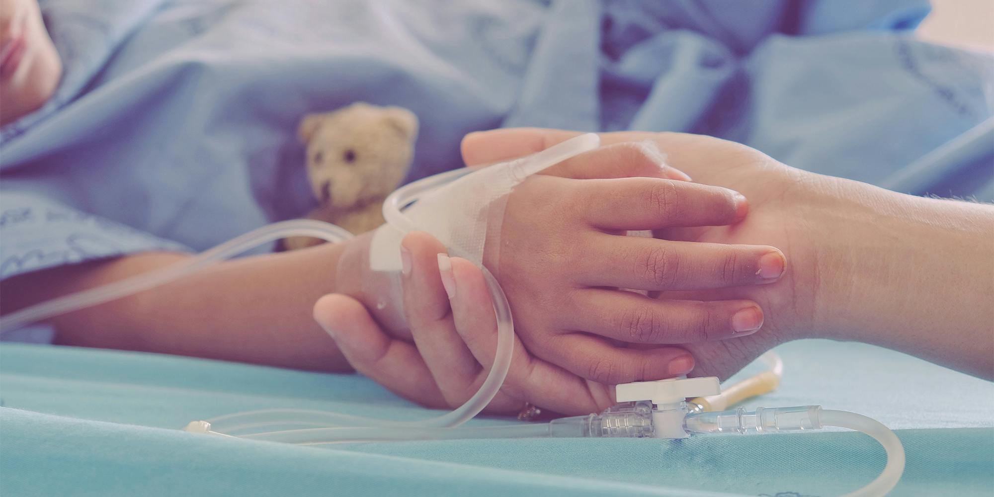 Mother holding child's hand who fever patients in hospital to give encouragement.