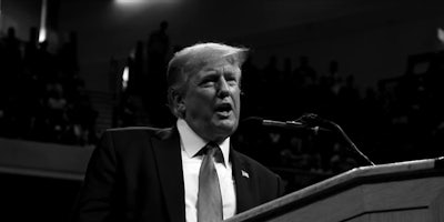Donald Trump speaking in microphone in black and white