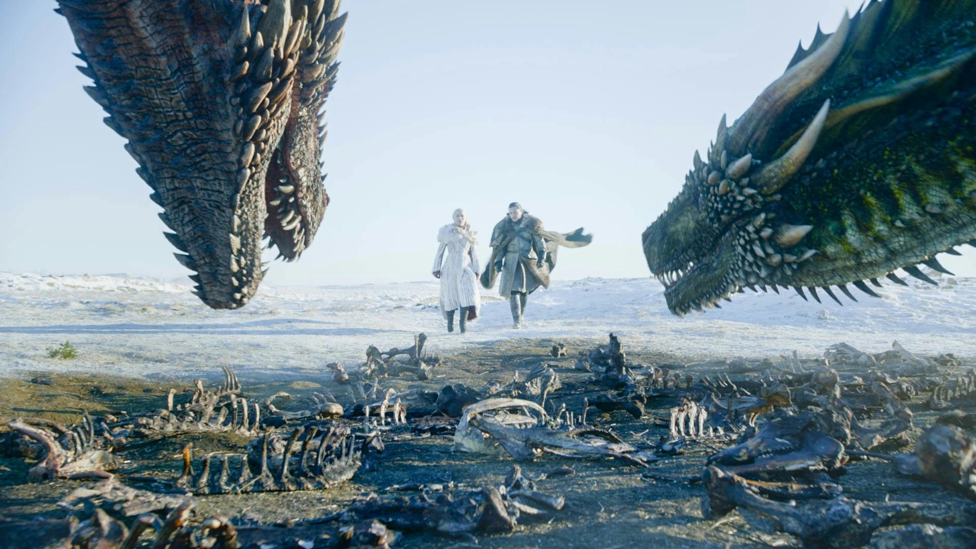 dany (left) and jon (right) approaching two dragons in game of thrones