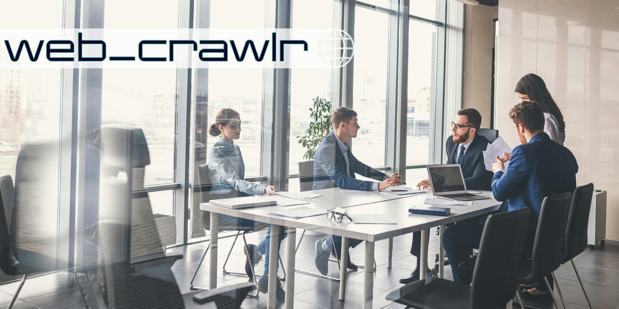 A group of workers around a conference room table. The Daily Dot newsletter web_crawlr newsletter is in the top left corner.