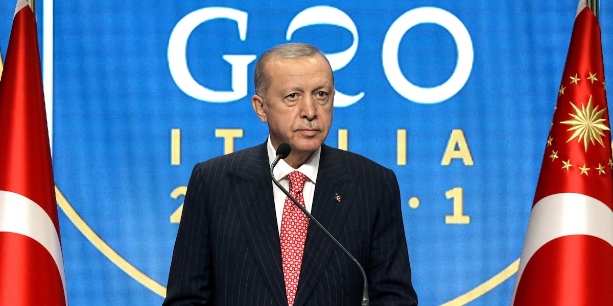 Recep Tayyip Erdogan speaking in front of blue background