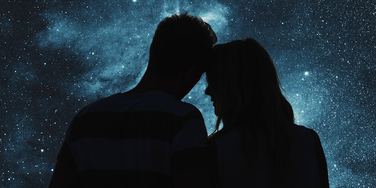 Silhouettes of a young couple under the starry sky