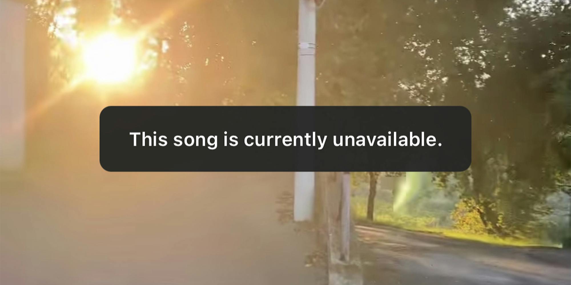 "This song is currently unavailable." over sunset background