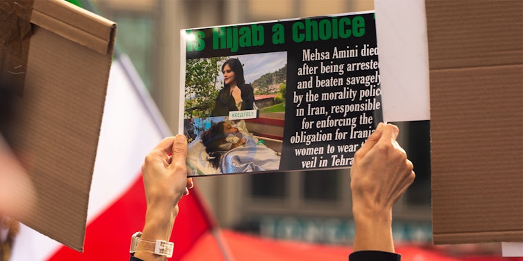 Protesters holding signs 'Is Hijab a choice Mesha Amini died after being arrested and beaten savagely by the morality police in Iran, responsible for enforcing the obligation for Iranian women to wear the veil in Tehra'