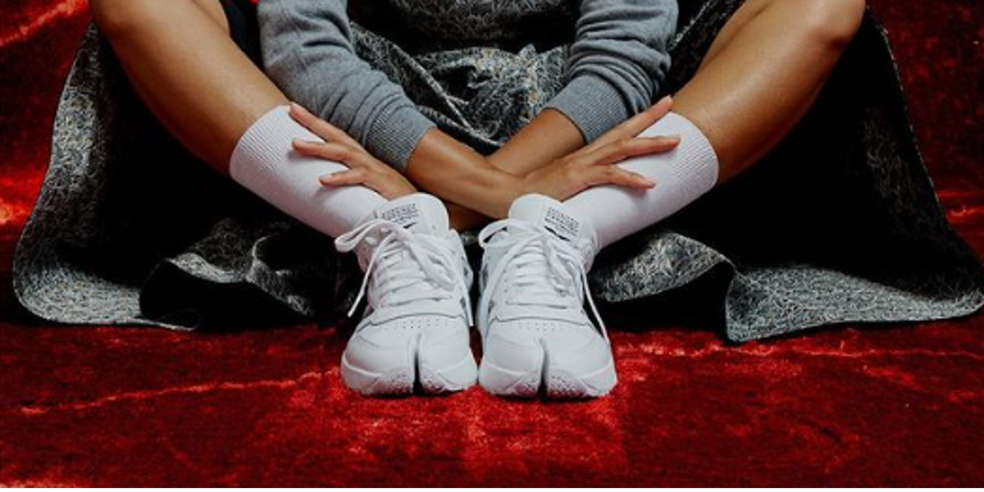 A woman wearing a pair of white Reebok shoes