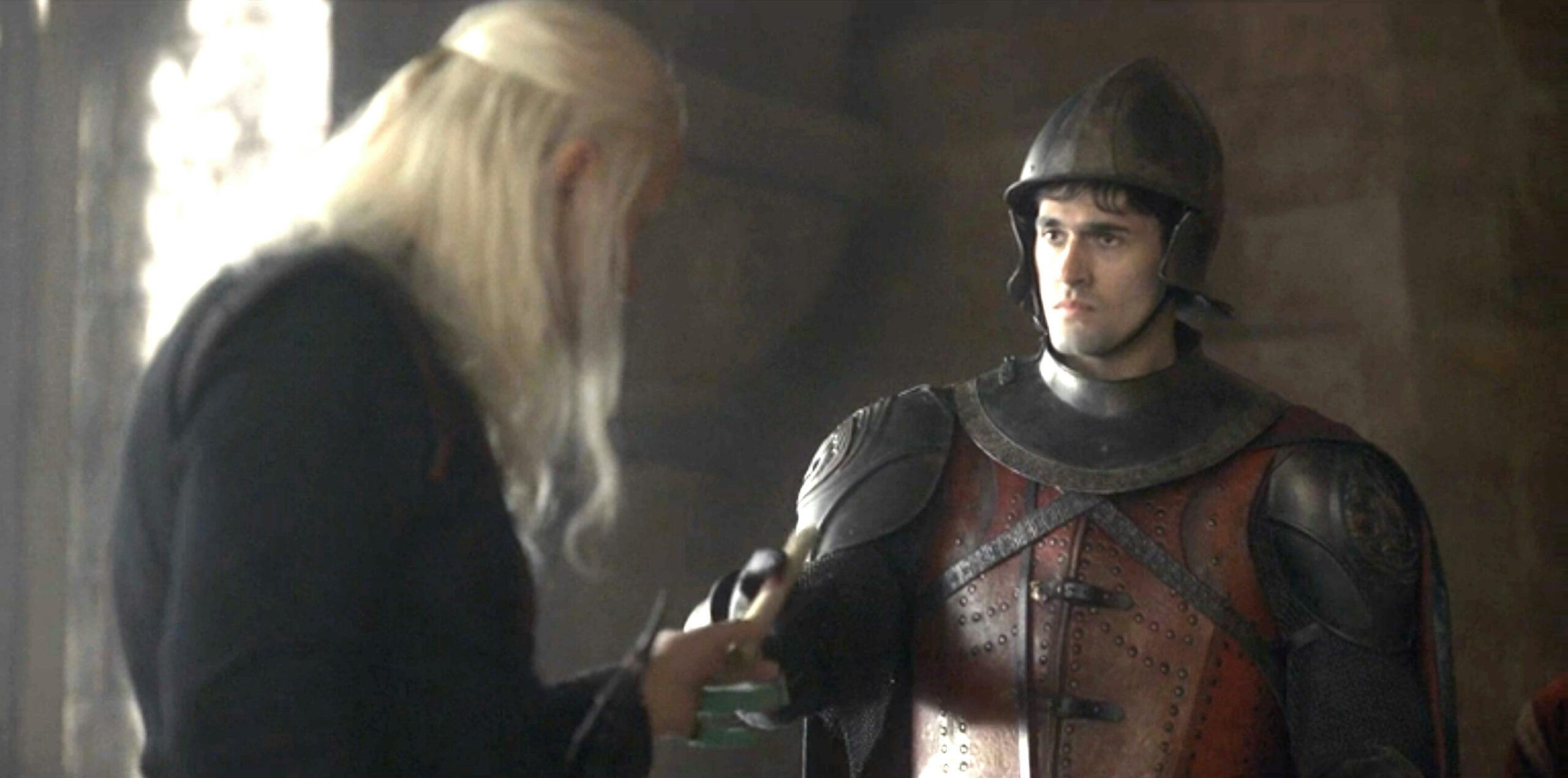 viserys targaryen (left) hands a scroll to a messenger (right) in house of the dragon