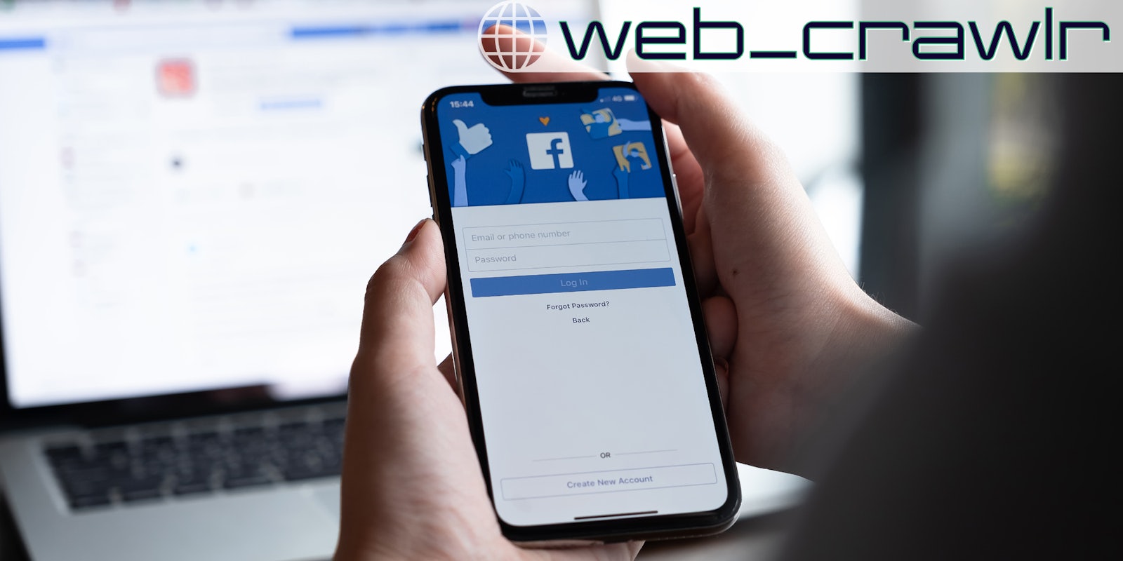 A person holding a smartphone with the Facebook login screen on it. The Daily Dot newsletter web_crawlr logo is in the top right corner.