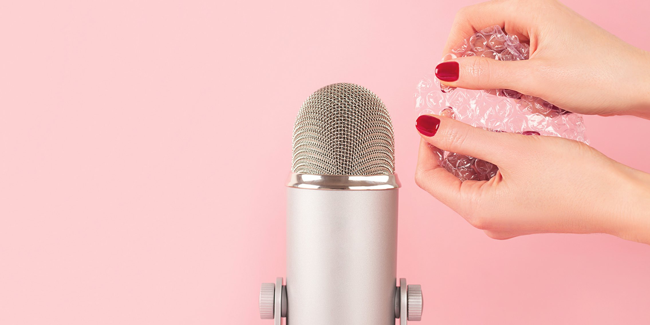 Woman hands with bubble wrap into a microphone, making ASMR sounds.