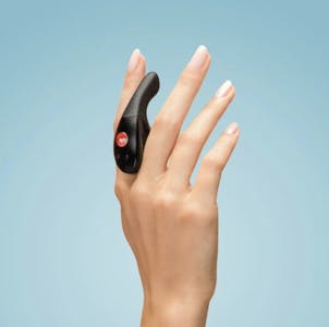 best quiet vibrator - A woman's hand holding the Fun Factory Be-One vibrator between her index and middle finger against a blue background.