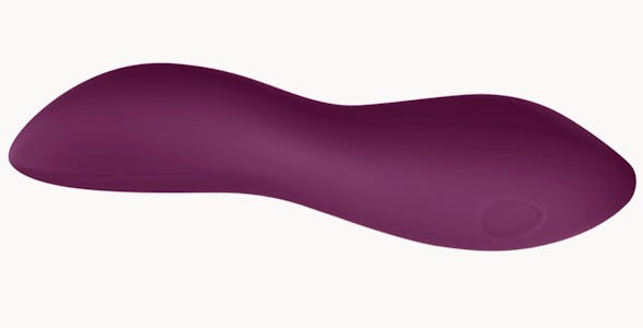 Plum-colored Dame dip vibrator in side view against a beige background.