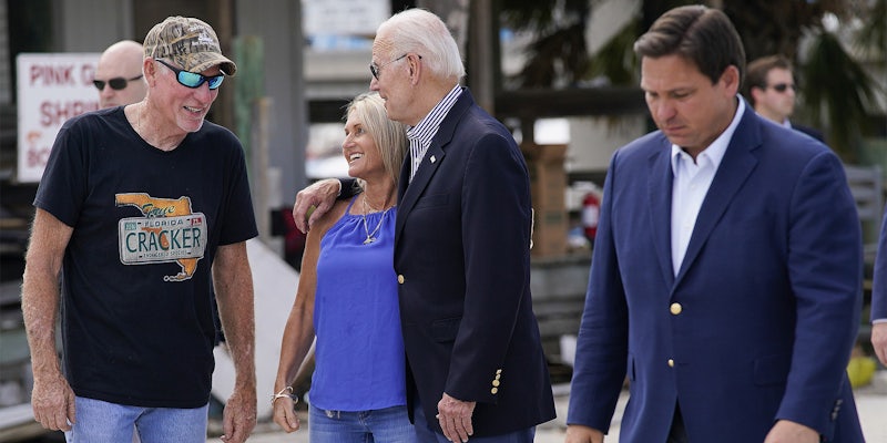 President Joe Biden talks with people impacted by Hurricane as Ron DeSantis walks by