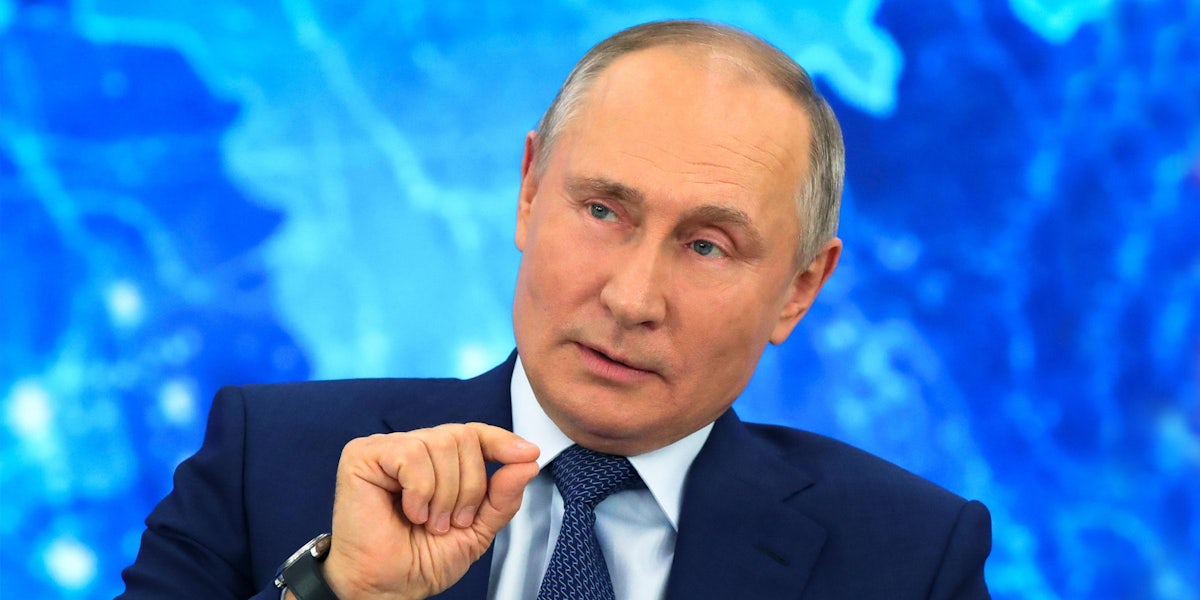 Vladimir Putin speaking in front of blue background