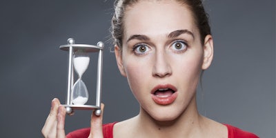 stunned beautiful young woman holding hourglass