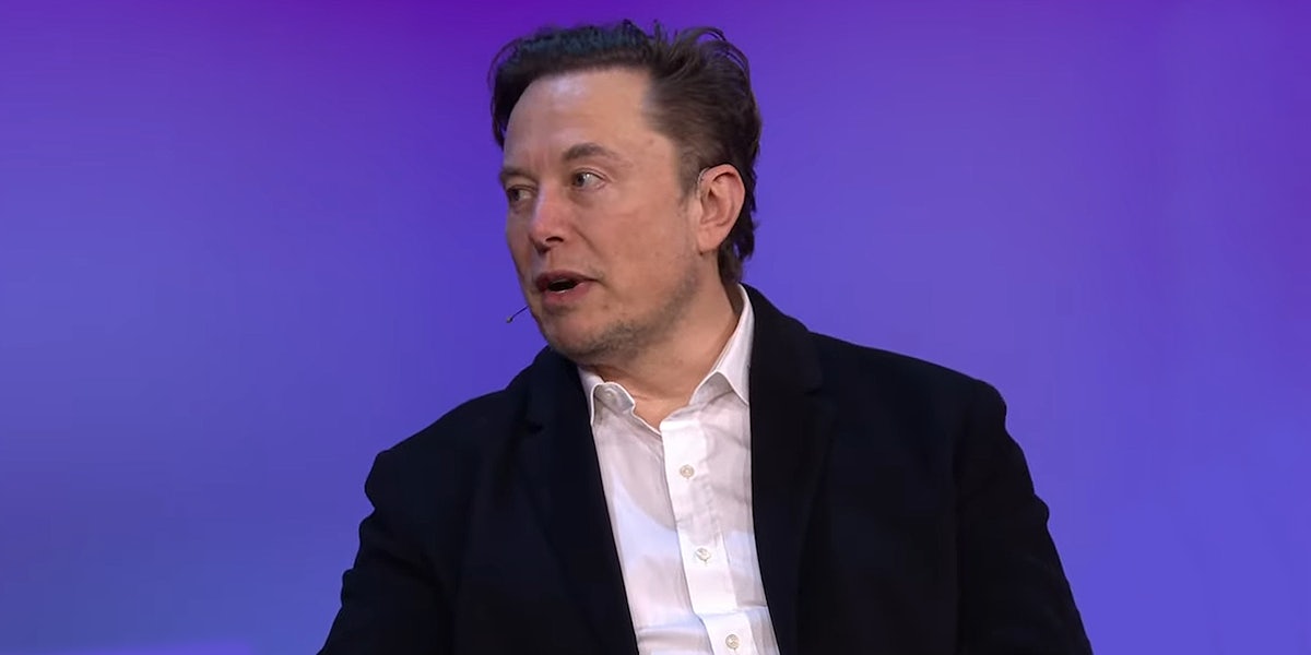 Elon Musk speaking in front of purple background