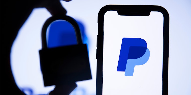 Paypal finance service logo on a smartphone, hand holding padlock