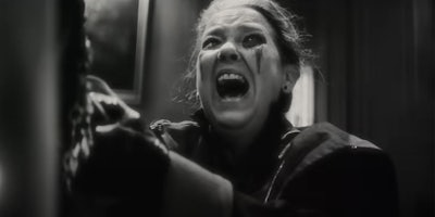 A still from 'Werewolf By Night' showing actor Harriet Sansom Harris screaming with blood on her face.