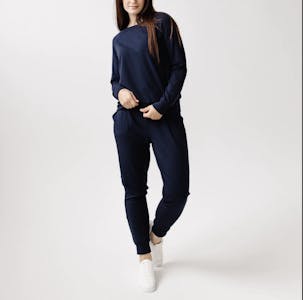 best cyber monday clothing deals - A woman in a navy blue bamboo jogging leisure suit from Cozy Earth.
