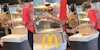McDonald's customer holding burger up at counter (l) McDonald's customer holding burger with ketchup on it with McDonald's golden arches 