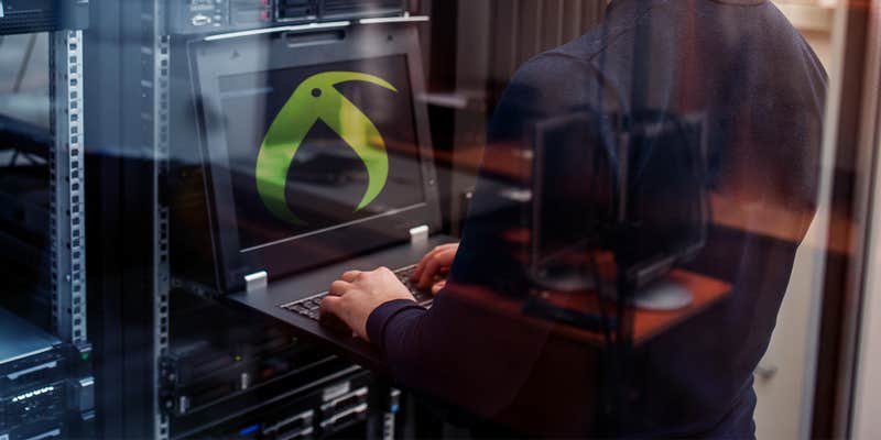 man on laptop in server room with kiwi farms logo