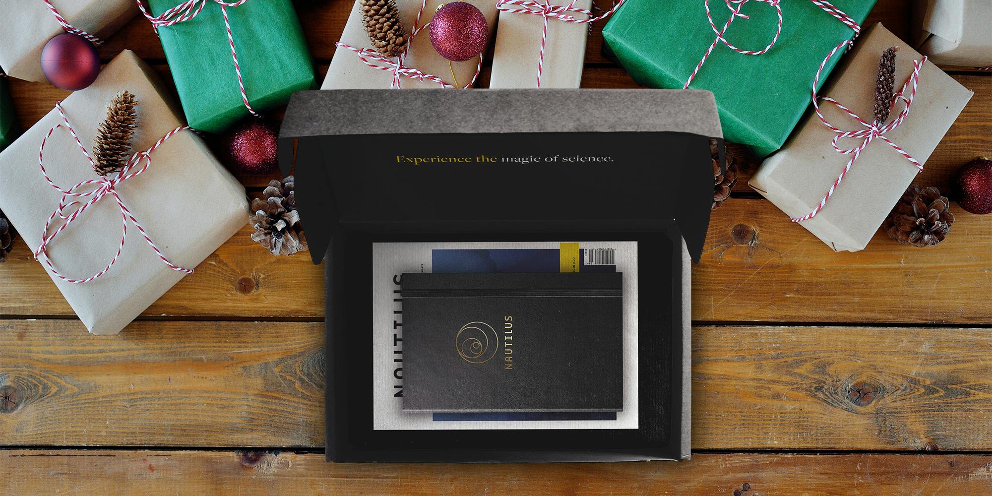 Nautilus subscription box on a wooden floor surrounded by wrapped gifts