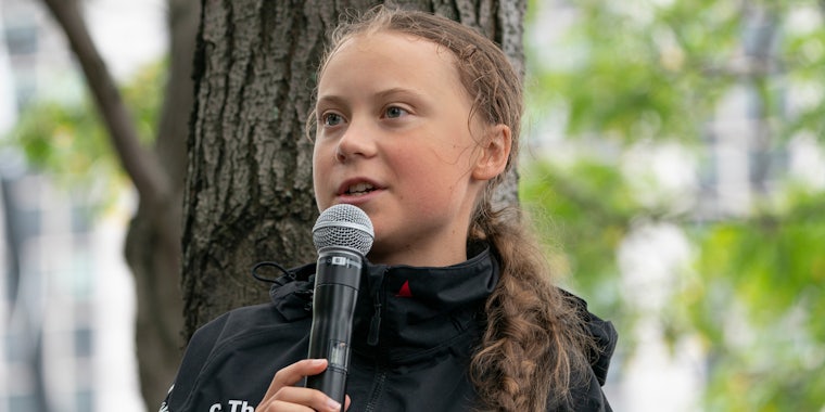 Greta Thunberg speaking into microphone outside