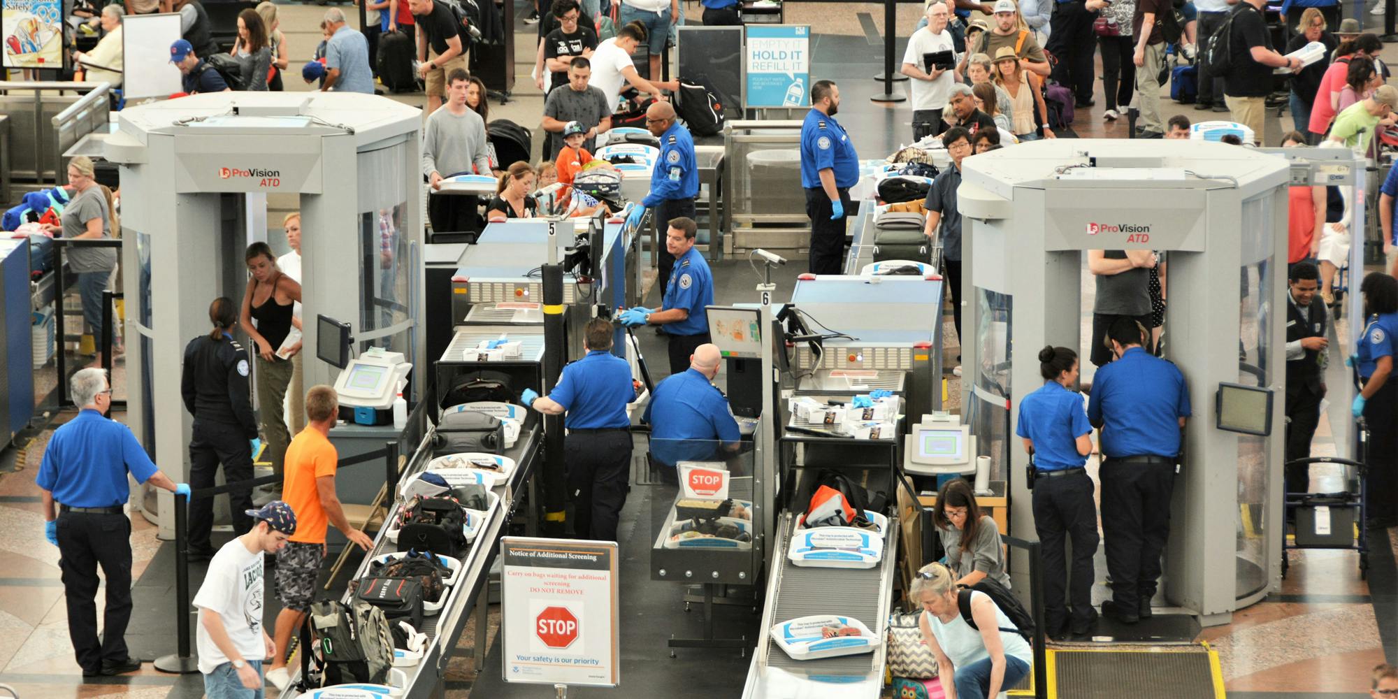 travelers in long lines at airport going thru the Transportation Security Administrations