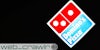 A Domino's pizza sign at night. The Daily Dot newsletter web_crawlr logo is in the bottom left corner.