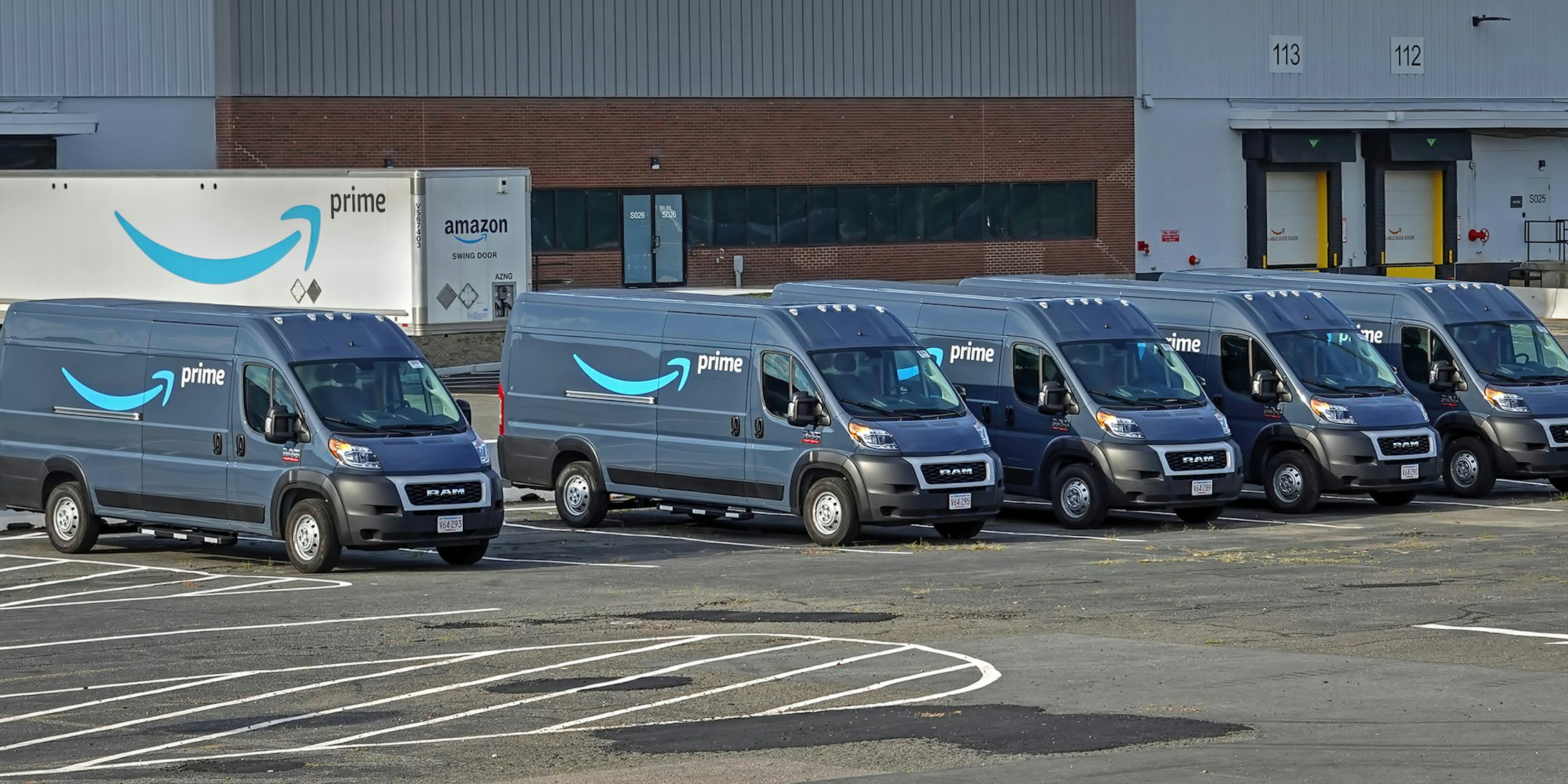 Amazon vans and truck in parking lot