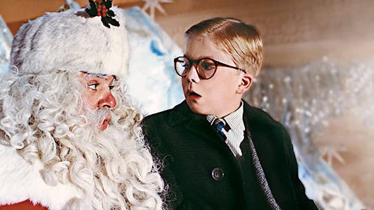 best christmas movies streaming - A young boy in glasses sitting on Santa's lap with a look of disbelief.
