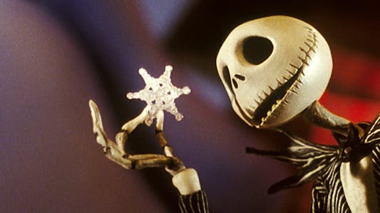 best Christmas movies streaming - A stop-motion skeleton holding a snowflake and examining it.