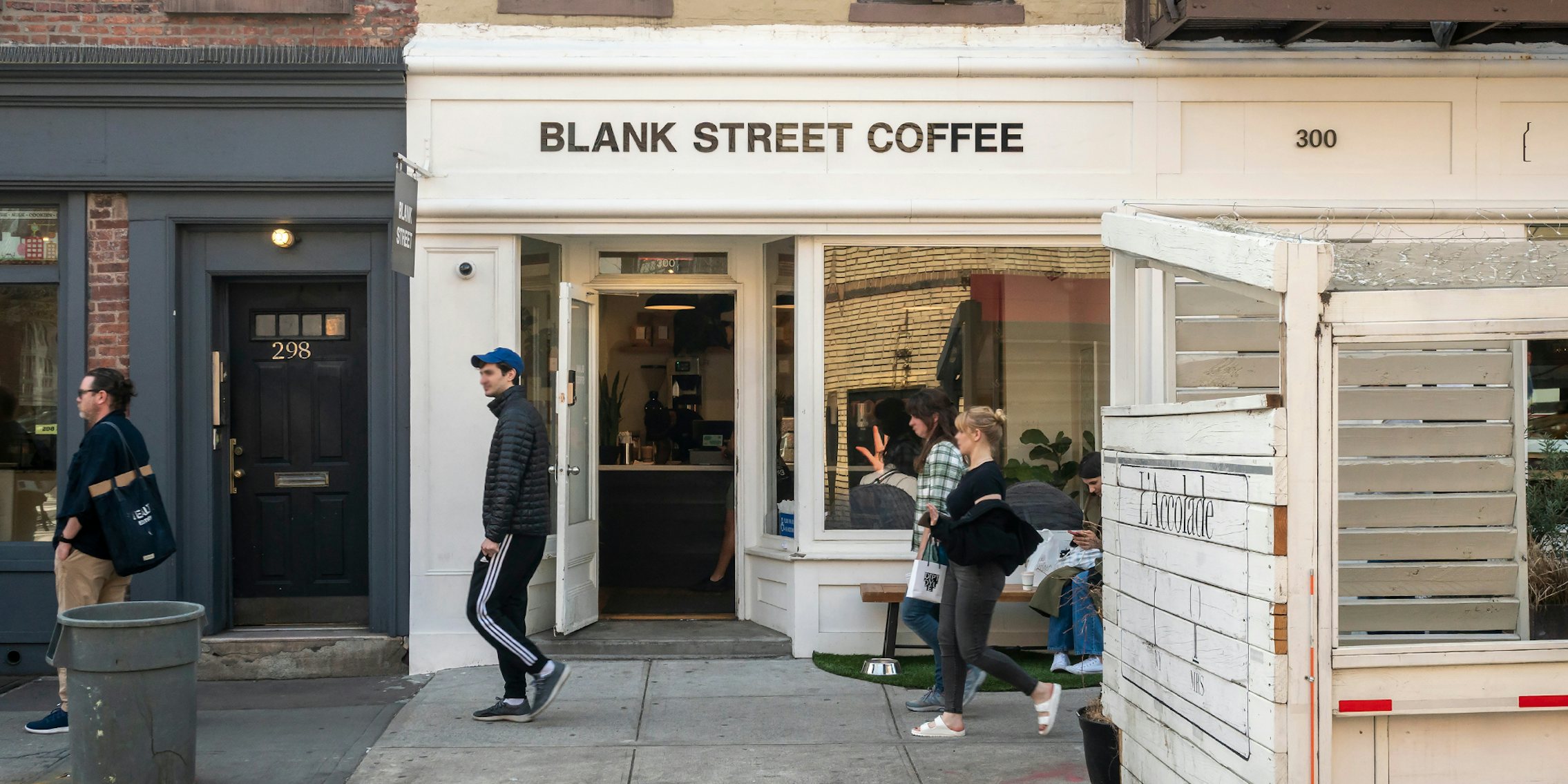 Blank Street Coffee building with sign and people walking by