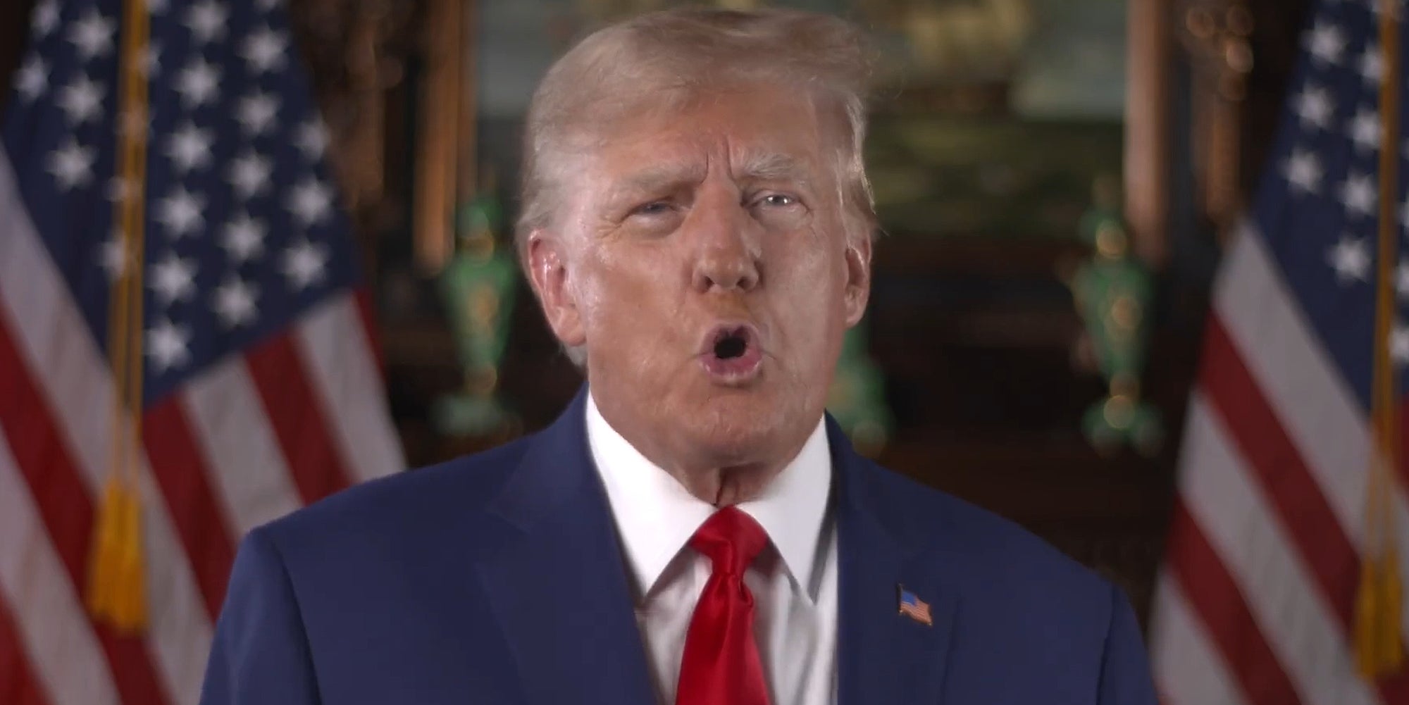 Donald Trump speaking in front of American Flags